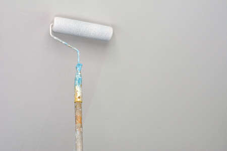 Paint roller on white wall with copy space.の写真素材
