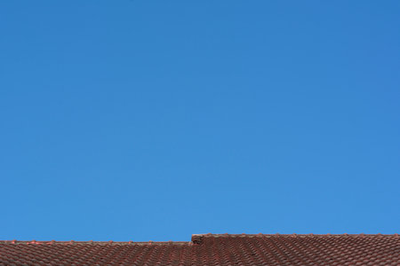 Red roof with tiles and the moon on sunny day with blue sky background. Nature landscape.の写真素材