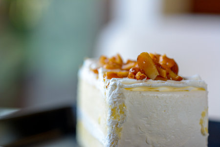 Closeup of almond cake on a black plate with natural light background.