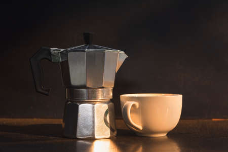 Moka pot and white cup on dark background. Coffee making concept.の写真素材