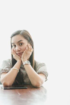 Pretty young woman working on a table with natural white background.