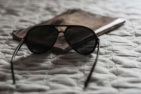 Closeup black sunglasses on white cloth background.