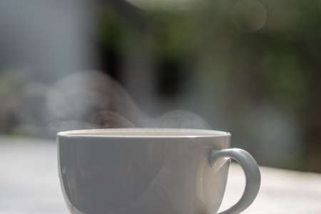 White coffee cup on natural blurred background.の写真素材