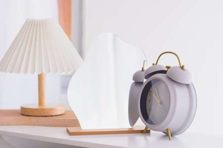 Alarm clock and mirror on natural light background
