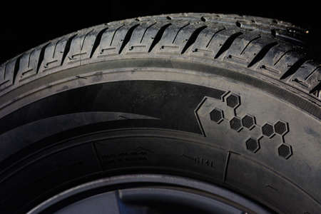 Closeup used tire isolated on dark background.