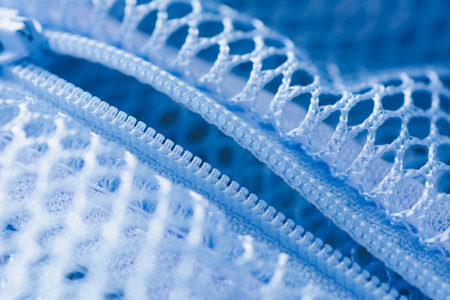 Close up shot of plastic zipper attached to blue nylon mesh bag.の写真素材