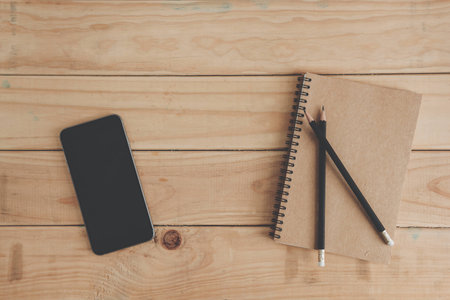 Business concept. business background. brown notebook, pencil and smartphone on wood office table....