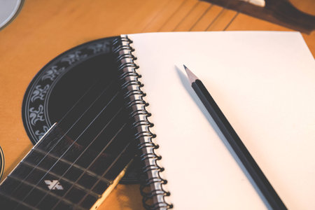 Notebook and pencil on guitar for writing music , Concept of musicの写真素材