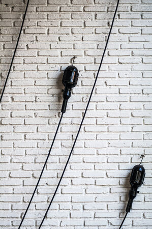Line of eletrical on the white brick wallの写真素材