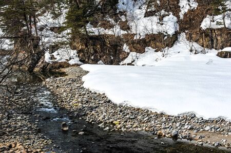 Beautiful snow covered on the stream in Japanの写真素材