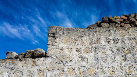 Ancient of block stone wall against blue skyの写真素材