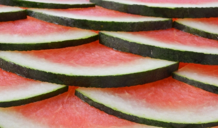 Abstract background with slices of fresh ripe red watermelons.