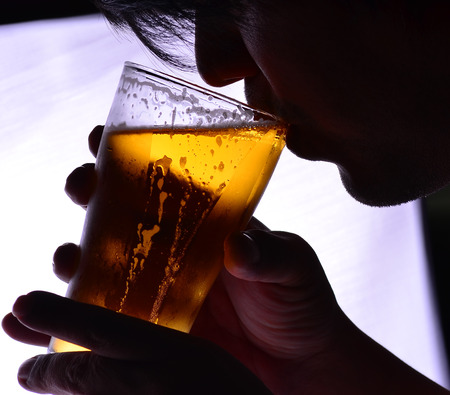 One man is drinking a glass of beerの写真素材
