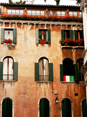 Italian windows with green shutters and flowersの写真素材