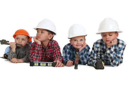 Boys laying down with tools wearing hardhatsの写真素材
