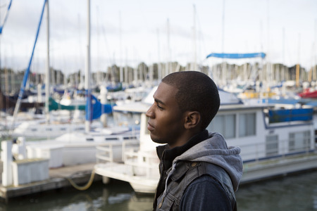 African American man pondering at boat marinaの写真素材