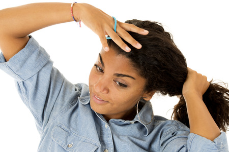 Attractive teen girl pulling hair into ponytail