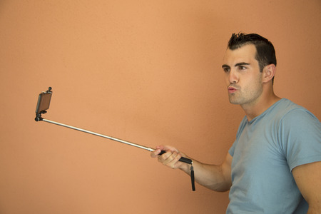 Cell phone selfie extender silly male modelの写真素材