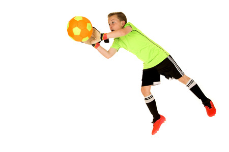 Young intense boy soccer goalie blocking shotの写真素材
