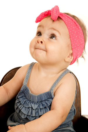Adorable baby girl looking up pink headbandの写真素材