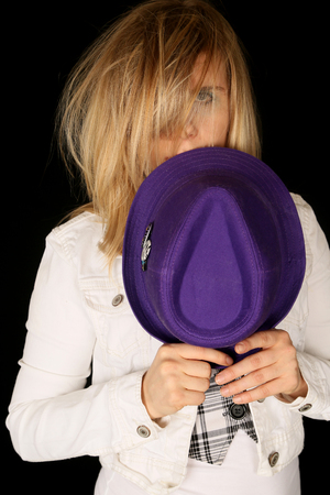 Girl holding purple hat with wild hairの写真素材