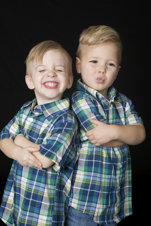 Portrait two cute boys standing arms foldedの写真素材