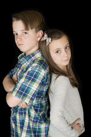 boy arms folded girl hands on hipsの写真素材