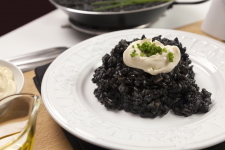 Traditional valencian dish made with rice, onion, garlic, squid and squid ink, accompanied by garlic mayonnaise sauceの写真素材