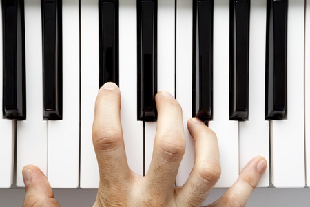 A hand playing the piano from a high angle viewの写真素材