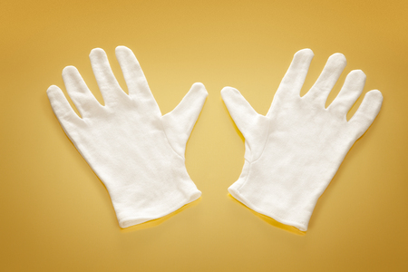 White gloves on a yellow reflective backgroundの写真素材
