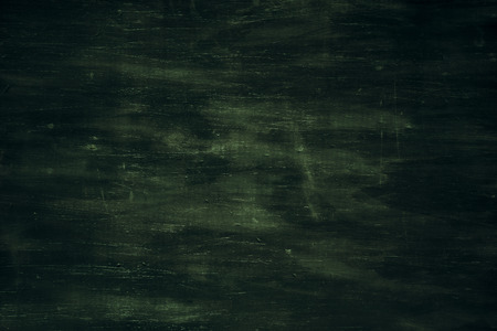 Dark green textured wooden background with an aged look and with scratches and dents.の写真素材