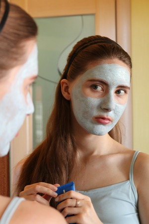 young woman taking care of her complexion layering moisturizerの写真素材
