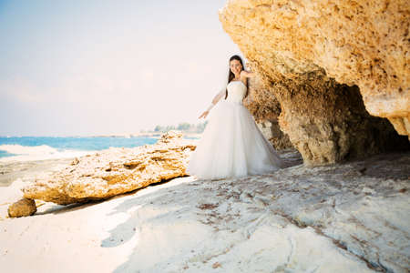 Happy beautiful woman in white wedding dress on the beach in paradise. Mediterranean Sea. Cyprusの写真素材