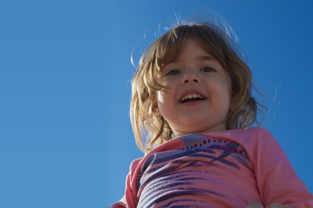laughing little girl on a background of the skyの写真素材