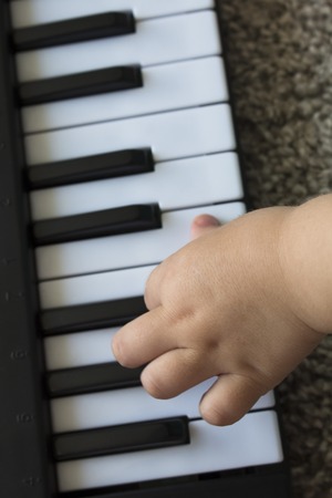 Childrens fingers on the keys of a piano playingの写真素材