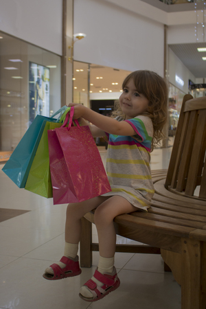 Happy girl holding shopping bags at the mallの写真素材