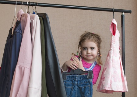 Adorable little girl choosing clothes and smilingの写真素材