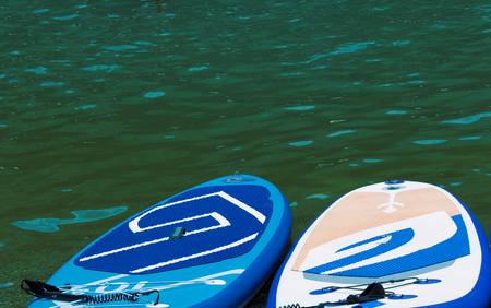 SUP Stand up paddle board on the background green water.の写真素材