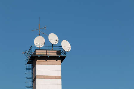 Satellite dish antenna on top of the building in urban area at sunny day.