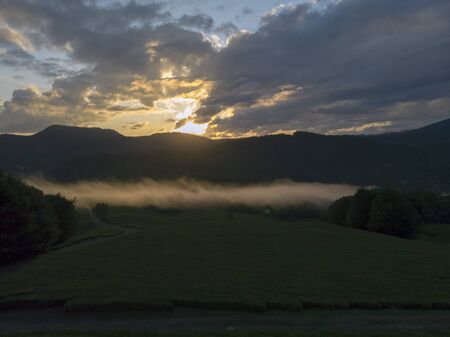 Amazing inspirational epic drone footage. Clouds of mist float over tea plantations against the backdrop of a magnificent sunset.の写真素材