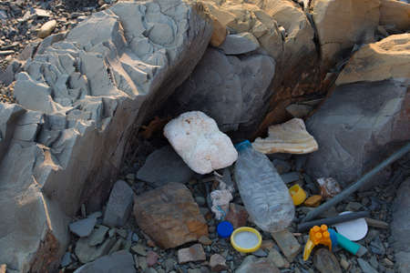 Spilled garbage on the beach. Empty used dirty plastic bottles. Dirty sea sandy shore the Black Sea. Environmental pollution. Ecological problem.の写真素材