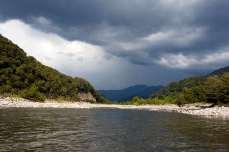 Beautiful landscape across countryside to mountains in distance with moody skyの写真素材