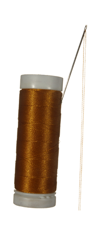 Spool of brown thread and needle isolated on white background.