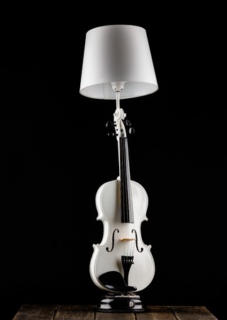 Handmade lamp from the white classical violin on the tableの写真素材