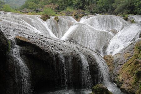 Water flowing down from the stonesの写真素材