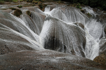 Water flowing down from the stoneの写真素材