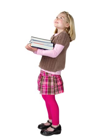 a cute school girl holding books and looking up at something or someone, isolated on a white backgroundの写真素材
