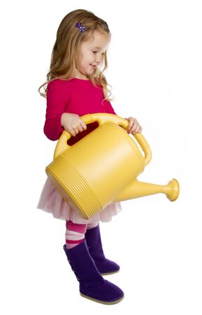 small girl holding a watering canの写真素材