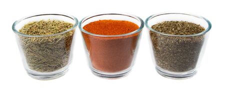 Three herbs and spices in glass jars, thyme, red pepper, and oregano, Isolated on a white backgroundの写真素材