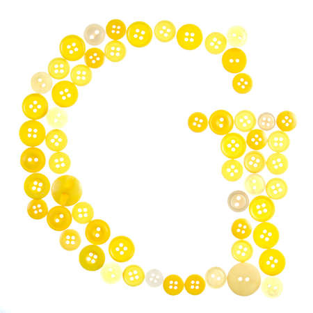 The letter G made of photographed buttons, isolated on a white backgroundの写真素材